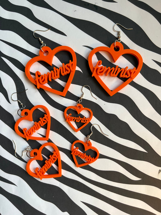 Orange hjärtan med texten feminist